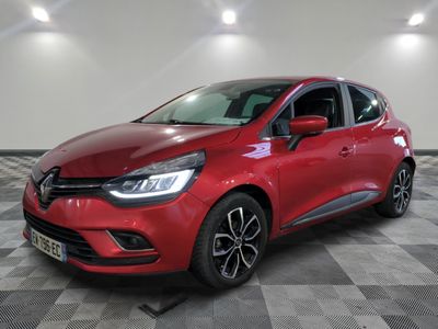 une voiture rouge est garée dans une pièce au sol en damier
