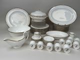 a lot of white and gold dinnerware on the table