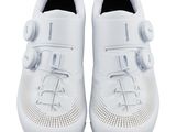 a pair of white shoes that are on a white surface