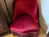 une chaise rouge qui se trouve dans le coin d'une pièce