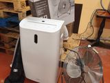 un climatiseur blanc posé à côté d'un ventilateur dans une pièce