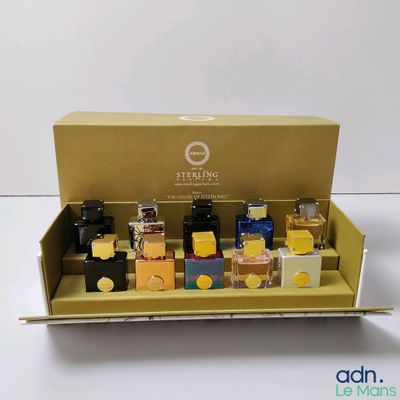 une présentation de différents types de parfums dans une boîte en carton