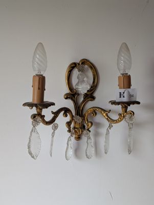 deux appliques murales sur un mur blanc, avec deux bougies
