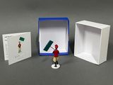 a small figurine of a man holding a flag in front of a box