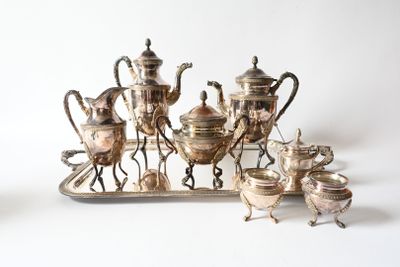 a silver tray with a silver tea set on top of it