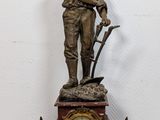 a bronze statue of a man holding a gun and a clock