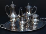 a silver tray with a silver tea set on it