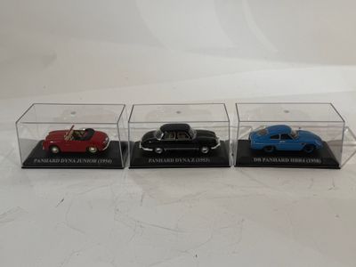 trois voitures miniatures sont exposées dans une vitrine posée sur une surface blanche