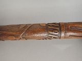an old wooden walking stick with carvings on it on a white surface