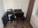 a small desk with a small refrigerator in the corner of the room