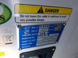 a sign on the side of a machine that says danger don ' t leave the cable in way to avoid any possible danger