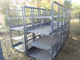 une cage métallique munie de plusieurs étagères, posée dans l'herbe