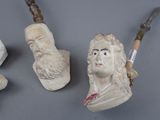 three statues of men with beards and a cane are on a gray surface