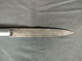 a knife with writing on it laying on a table