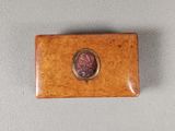 a close up of a small wooden box with a coin on it