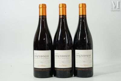 trois bouteilles de vin posées sur une table blanche