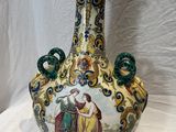 un vase avec un tableau posé sur une table