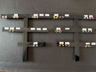 a black wall with a bunch of earrings hanging on it