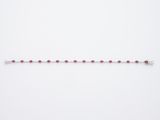 un bracelet de perles rouges sur fond blanc