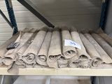 several rolls of carpet are stacked on a shelf in a warehouse