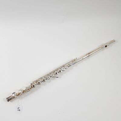 a silver flute on a white surface with a white background