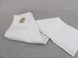 the white pants are on the bed with a tag on them
