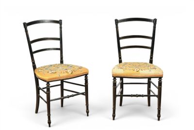 pair of black painted chairs with floral upholstered seat cushions