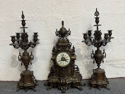 three antique clocks sitting next to each other on the floor