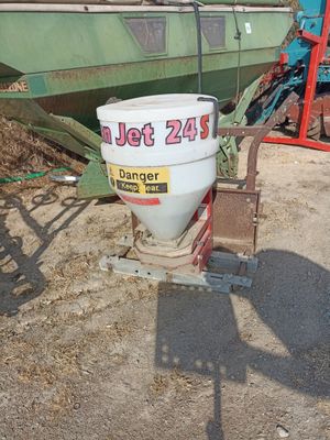 a white bucket sitting on the ground next to a green boat
