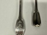 two silver spoons and a fork on a white surface