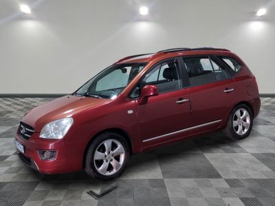 la voiture rouge est garée sur un sol en damier dans le garage