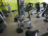 des rangées de vélos d'appartement dans une salle de sport aux murs verts