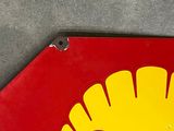 a red and yellow sign with a shell logo on it