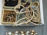 une boîte remplie de perles et d'autres bijoux posée sur une table