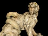 marble statue of a lion with yellow eyes on a black background