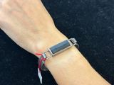 someone is wearing a bracelet that has a metal clasp on it