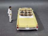 a man standing next to a toy car with a dog in it