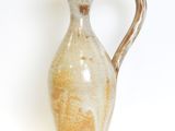 a brown and white vase sitting on a white surface