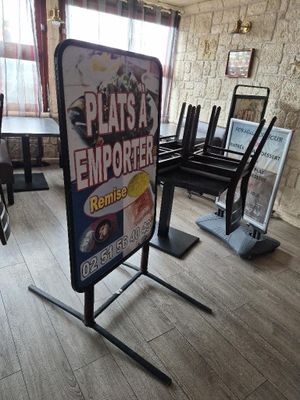 un panneau au milieu d'une pièce où se trouvent des chaises et une table