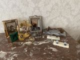 une table sur laquelle se trouvent un cadre photo, un cadre photo, un bougeoir, un cadre photo et d'autres objets