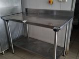 a stainless steel table in the middle of a kitchen