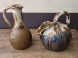 two vases that are sitting on a wooden table