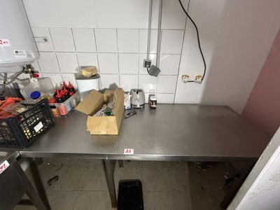 une photo d'une cuisine avec une table et une poubelle