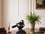 a statue of a bird sitting on top of a desk