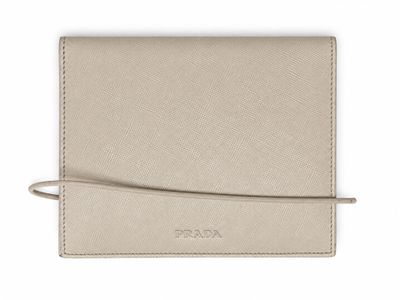 a beige leather wallet with a small strap on the front
