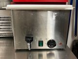 plan de travail en acier inoxydable dans une cuisine professionnelle, sur lequel est posé un saladier