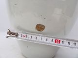 a measuring tape on a white vase with a hole in it