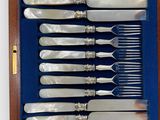 silverware in a wooden box on a white surface