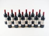 several bottles of wine are lined up in a row on a white surface