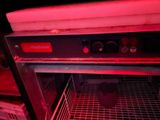 a red light shining on the inside of an oven